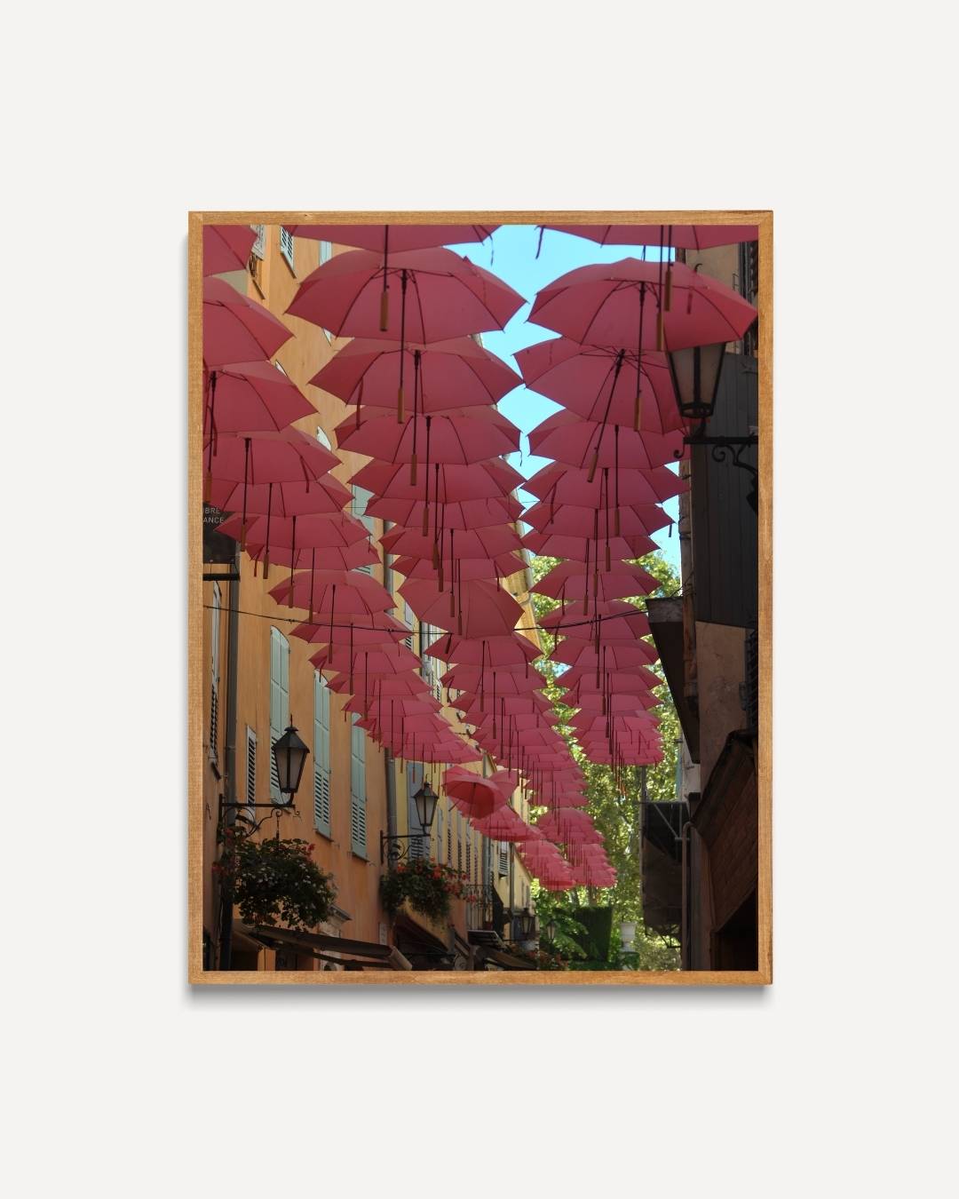 Roze paraplu's boven een zonnige straat Poster – portret poster als wanddecoratie
