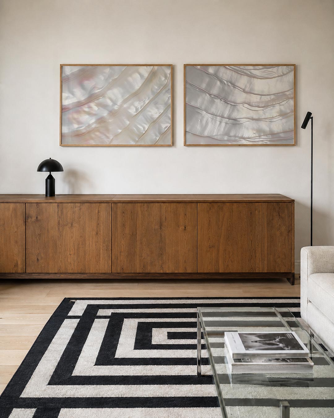 Twee liggende posters met een spel van glanzende, golvende lijnen in zachte parelmoertinten, aan de muur in een interieur