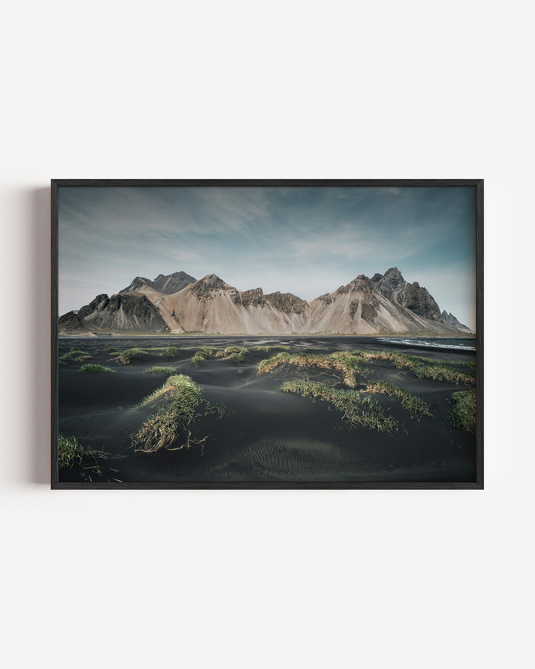 Berglandschap poster – liggende wanddecoratie – een indrukwekkend berglandschap met zwarte zandvlakten en groene grasvlakken.
