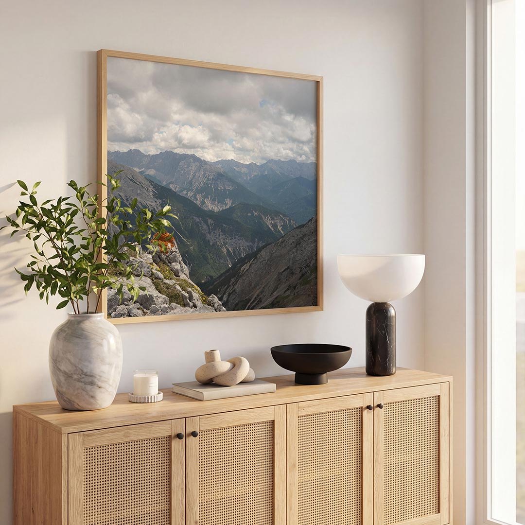 Berglandschap met wolken poster – tweede productweergave – een berglandschap met wolkenluchten en een rots met oranje mos op