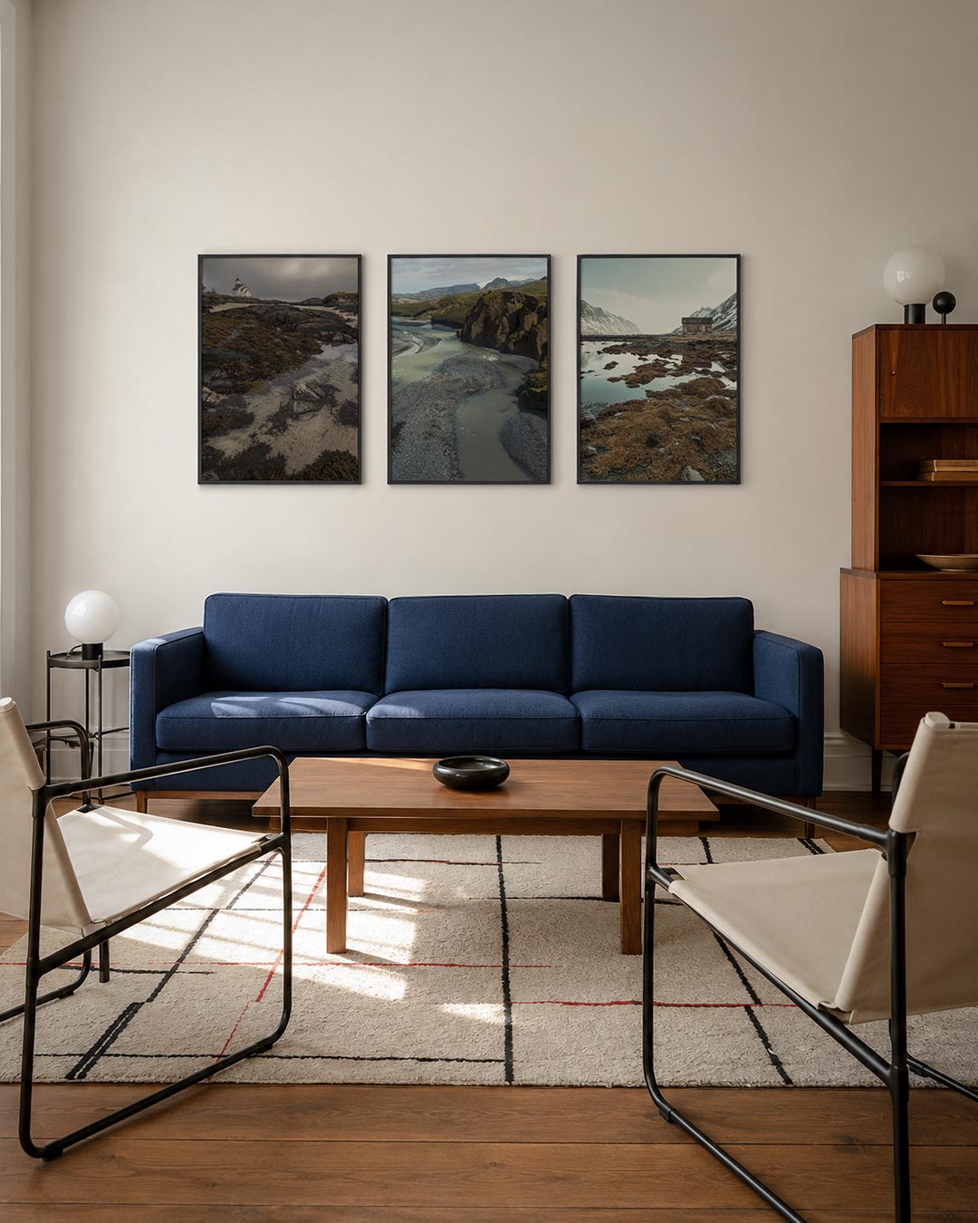 Rustige kustlijn driedelige posterset – een serene kustlijn met een wit gebouw op de achtergrond. Donkere rotsen en zeewier