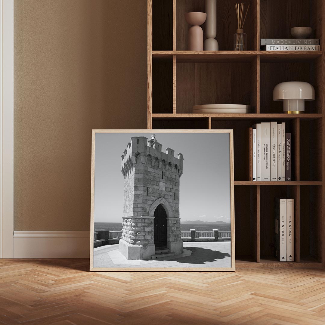 Toren poster – derde productweergave – deze poster toont een robuuste stenen toren met een deur, omgeven door een serene zee