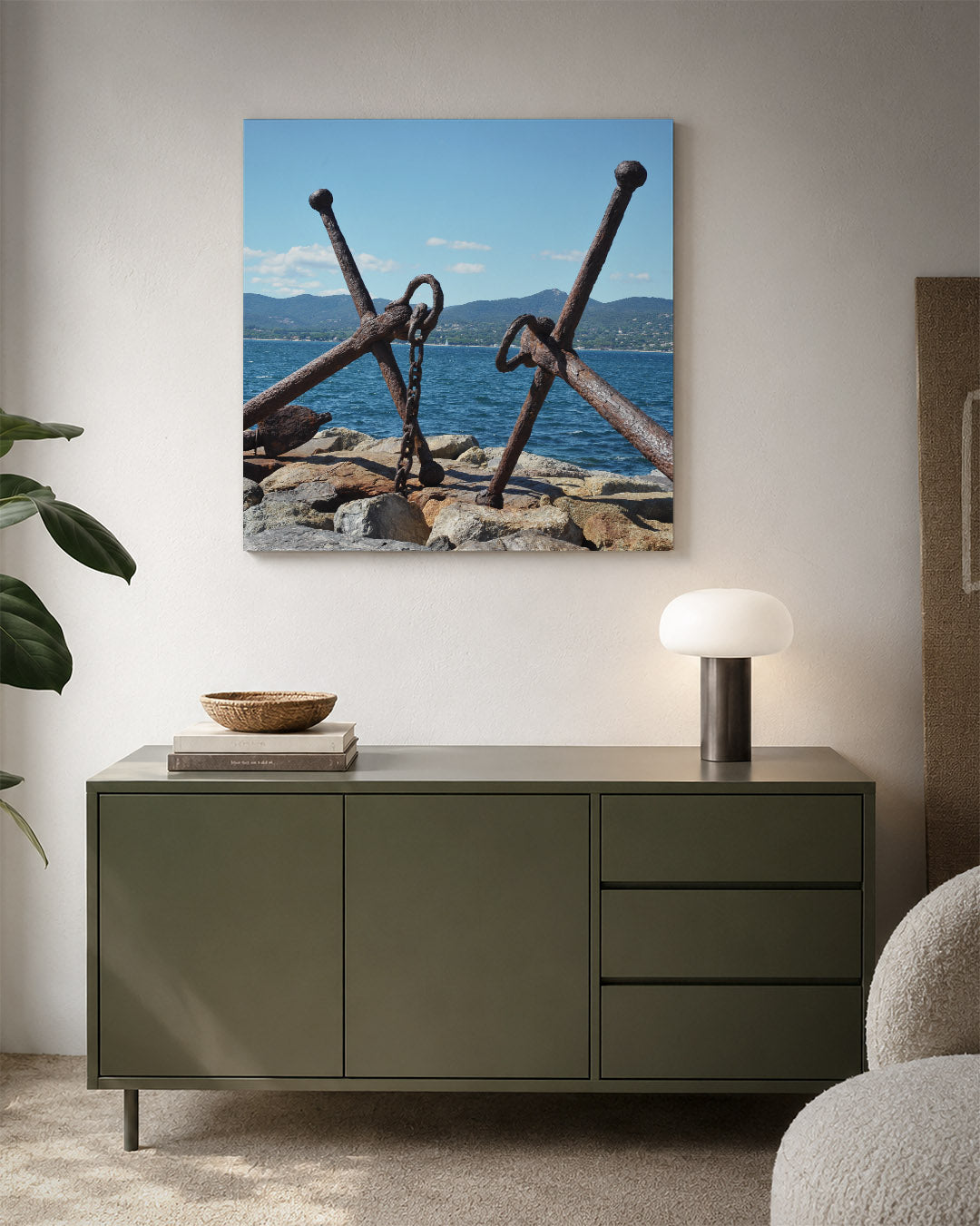 Ankers aan zee kunstwerk – detailweergave – twee verweerde ankers rusten op rotsen aan de kust, met een blauwe zee en heuvels