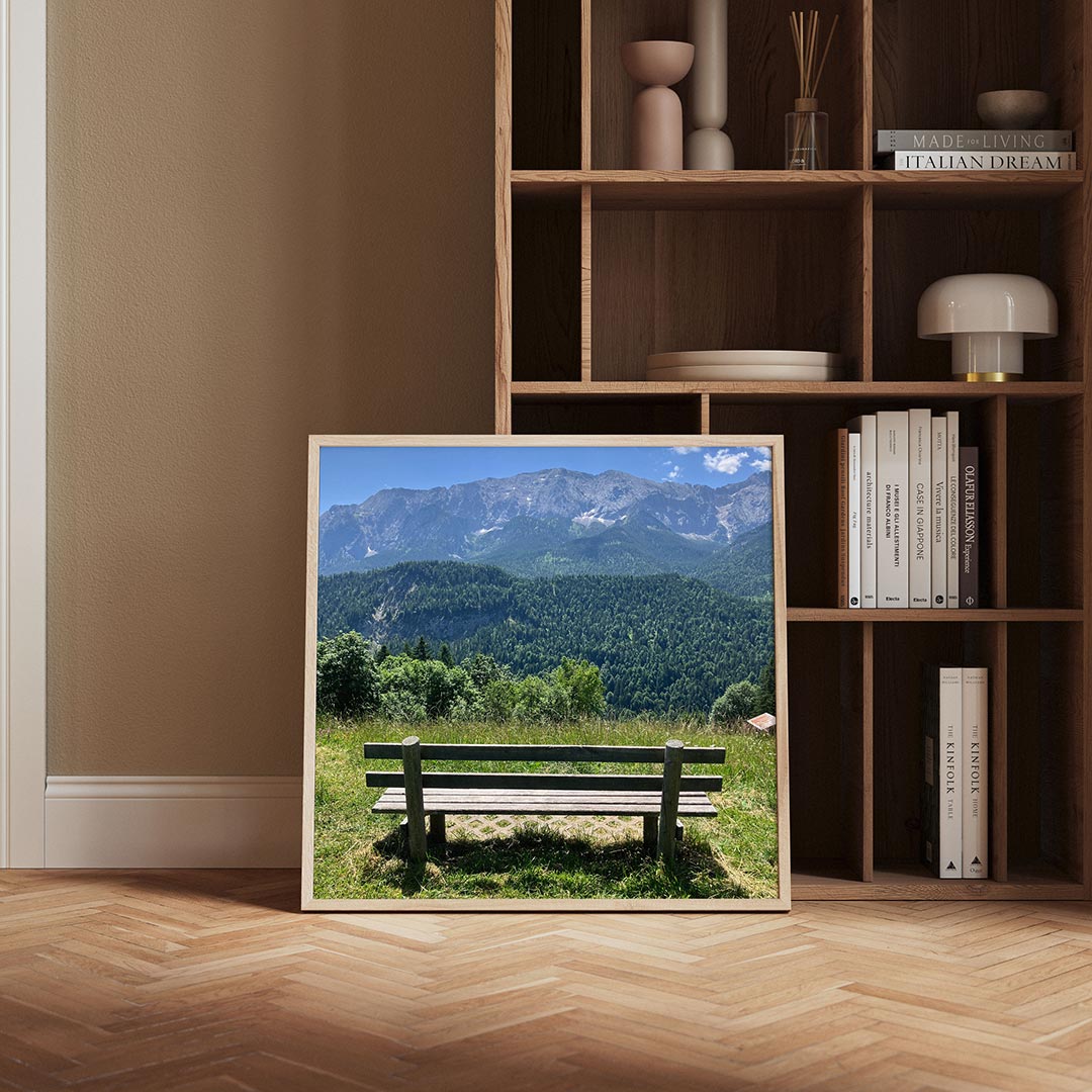 Berglandschap poster – derde productweergave – een houten bankje staat op een groene heuvel met uitzicht op een bos en bergen