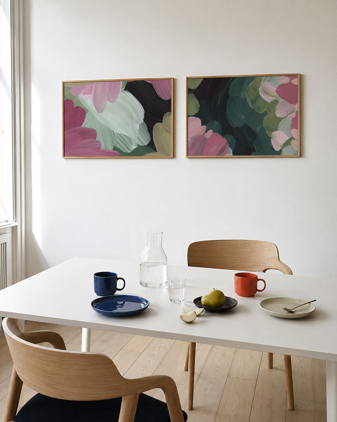 Interieurbeeld met twee liggende posters: deze tweedelige posterset heeft roze, groene en witte kleurvlakken