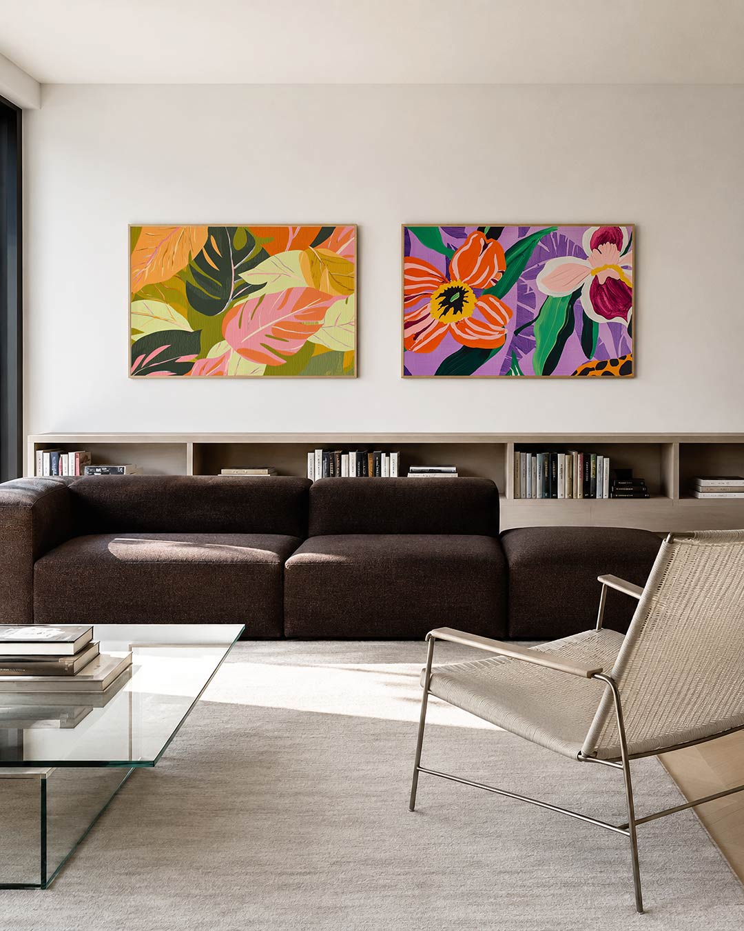 Twee liggende posters met grote bladeren in roze, groen en oranje tinten, aan de muur in een interieur