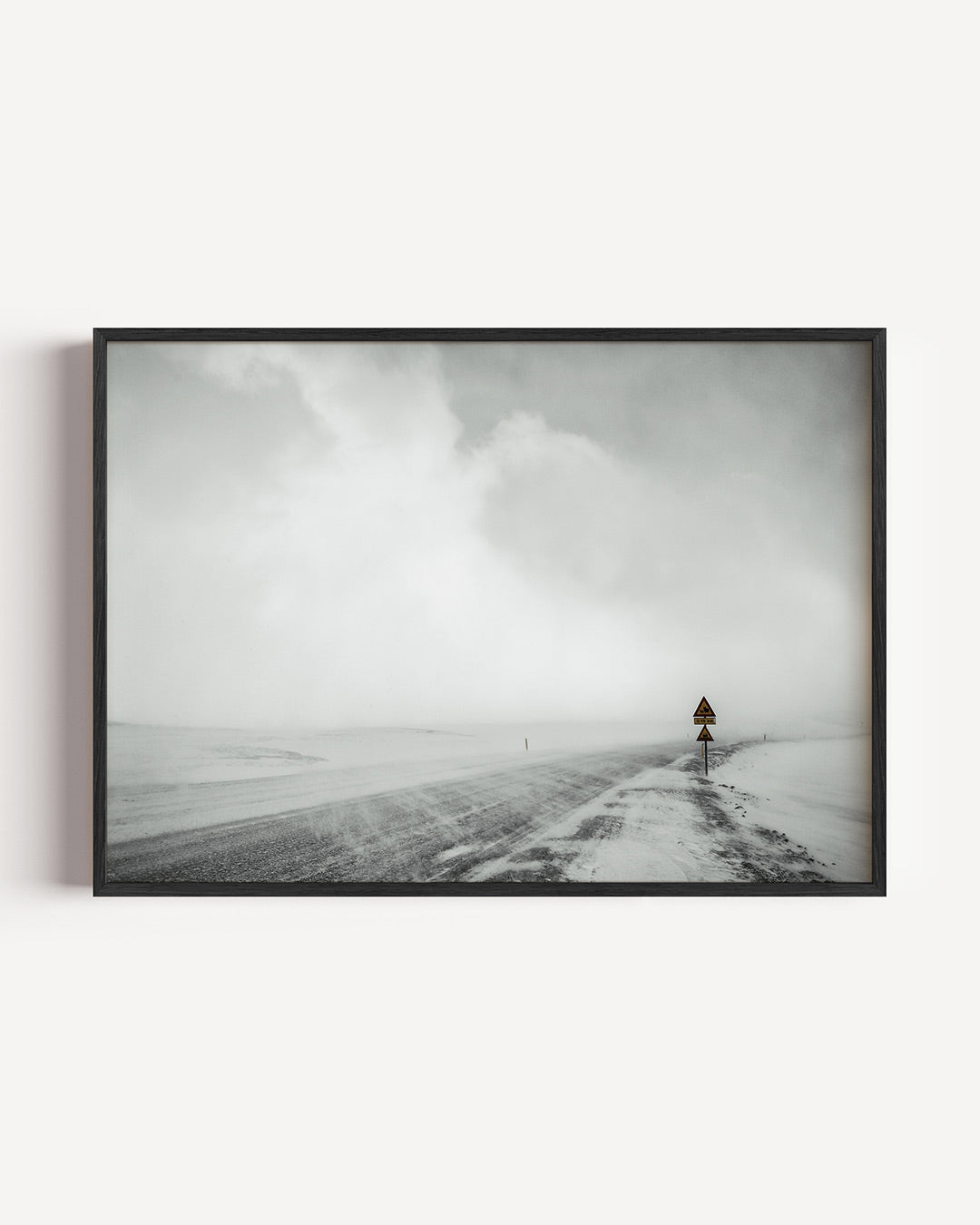 Winderige sneeuwweg poster – liggende wanddecoratie – een verlaten weg bedekt met sneeuw, omgeven door een mistige lucht. Een