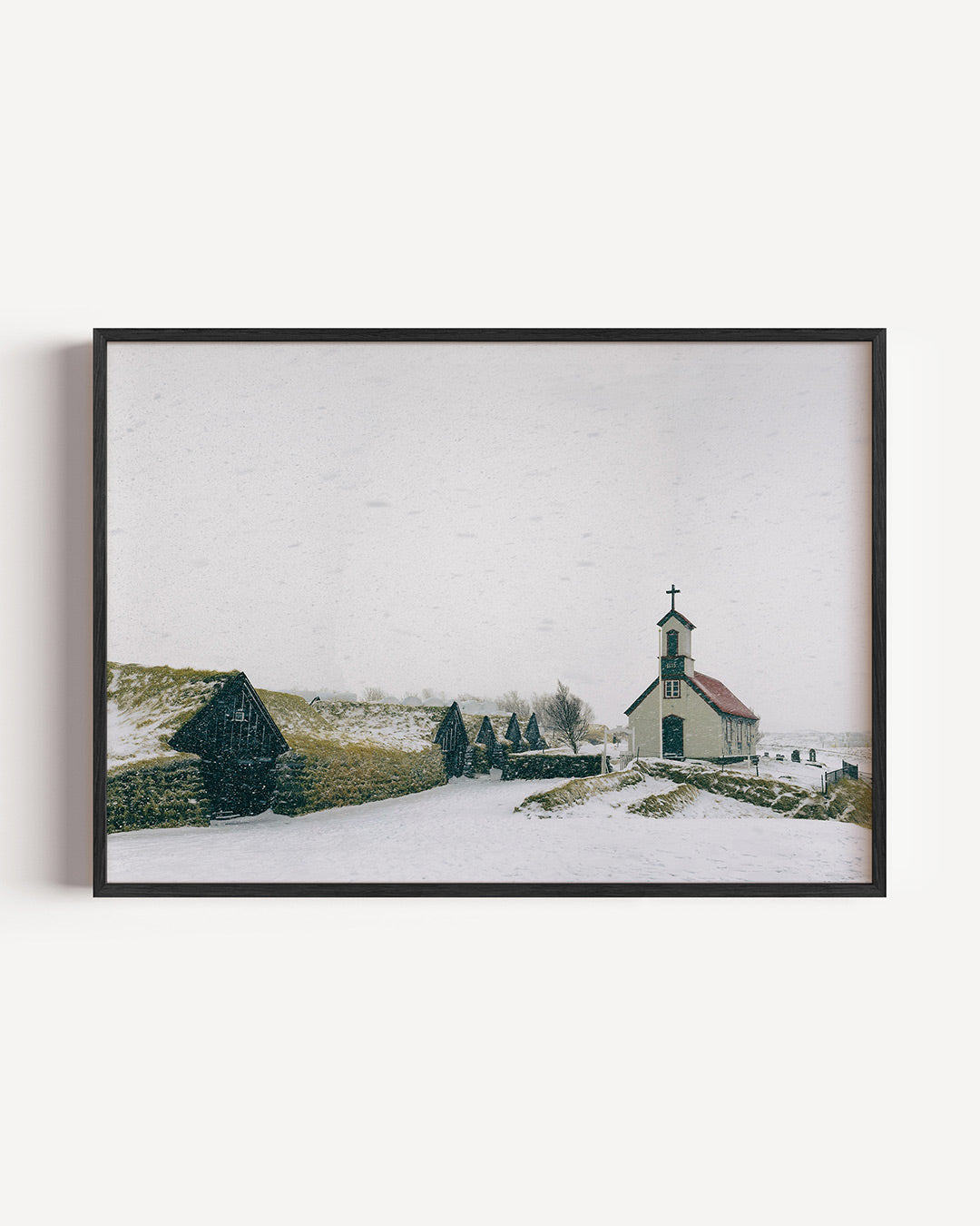Winterlandschap poster – liggende wanddecoratie – een winterse scène met een gebouw en huisjes bedekt met sneeuw. De