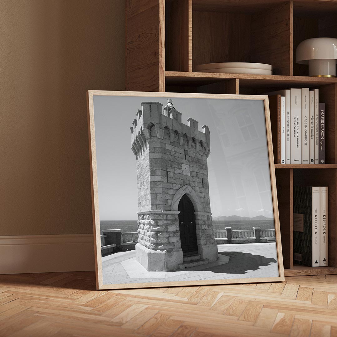 Toren poster – detailweergave – deze poster toont een robuuste stenen toren met een deur, omgeven door een serene zee en