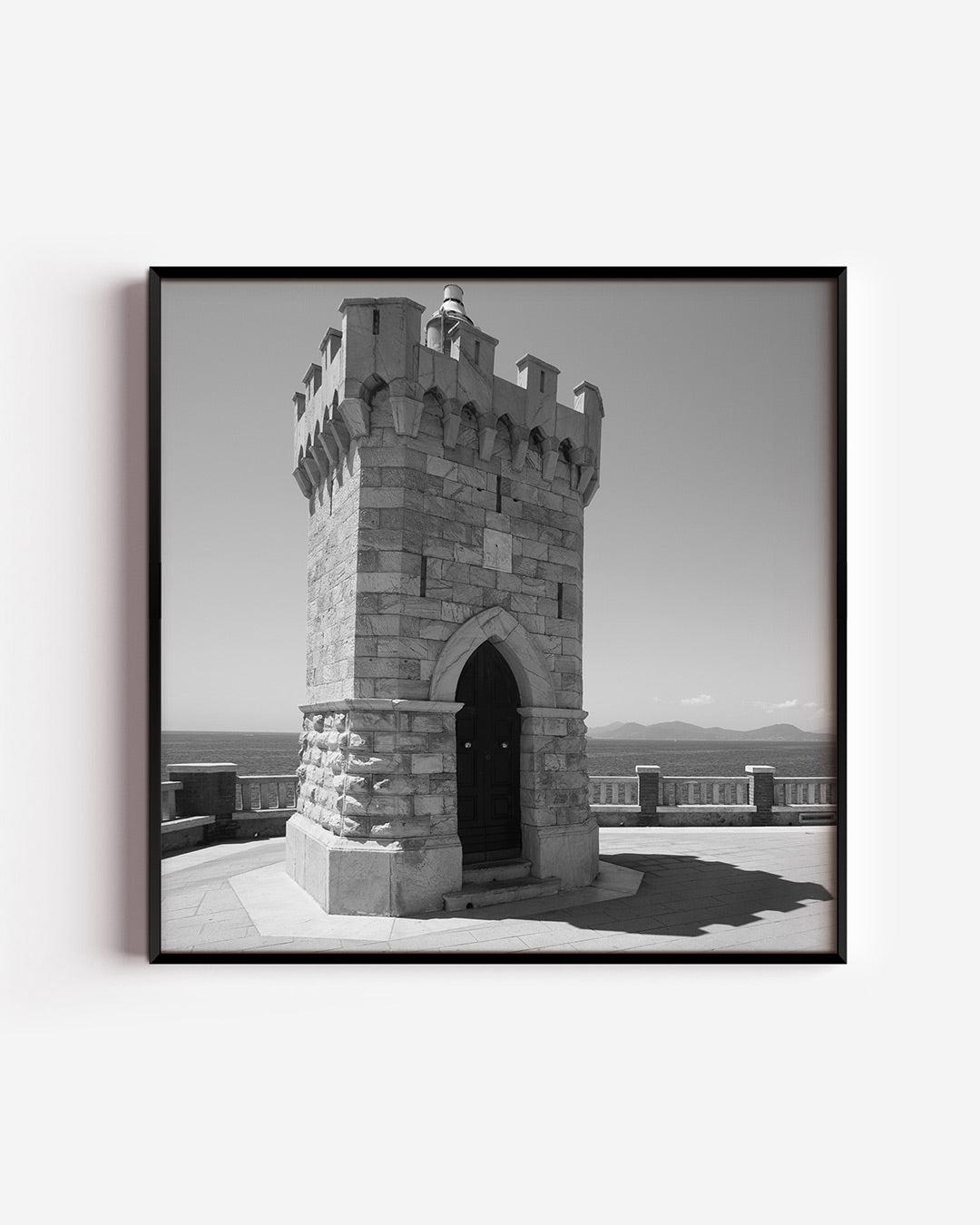 Toren poster – vierkante wanddecoratie – deze poster toont een robuuste stenen toren met een deur, omgeven door een serene