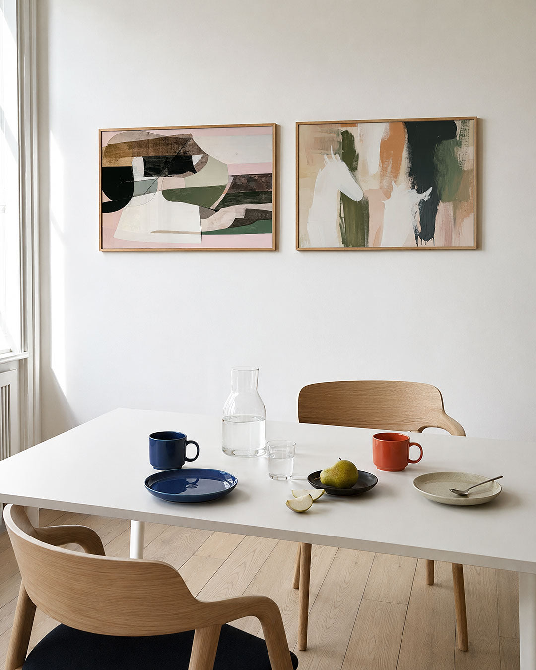 Twee liggende posters met een spel van overlappende kleurvlakken en vloeiende lijnen, aan de muur in een interieur