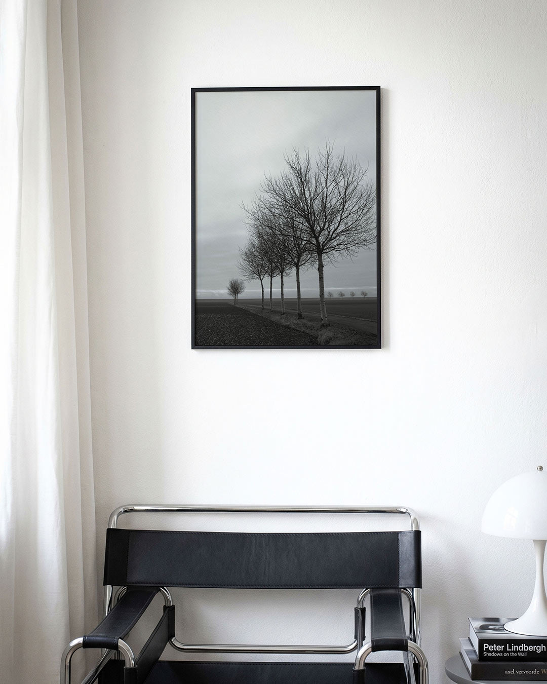 Landschap met bomenrij poster – derde productweergave – een rij kale bomen langs een weg in een open landschap. De lucht is