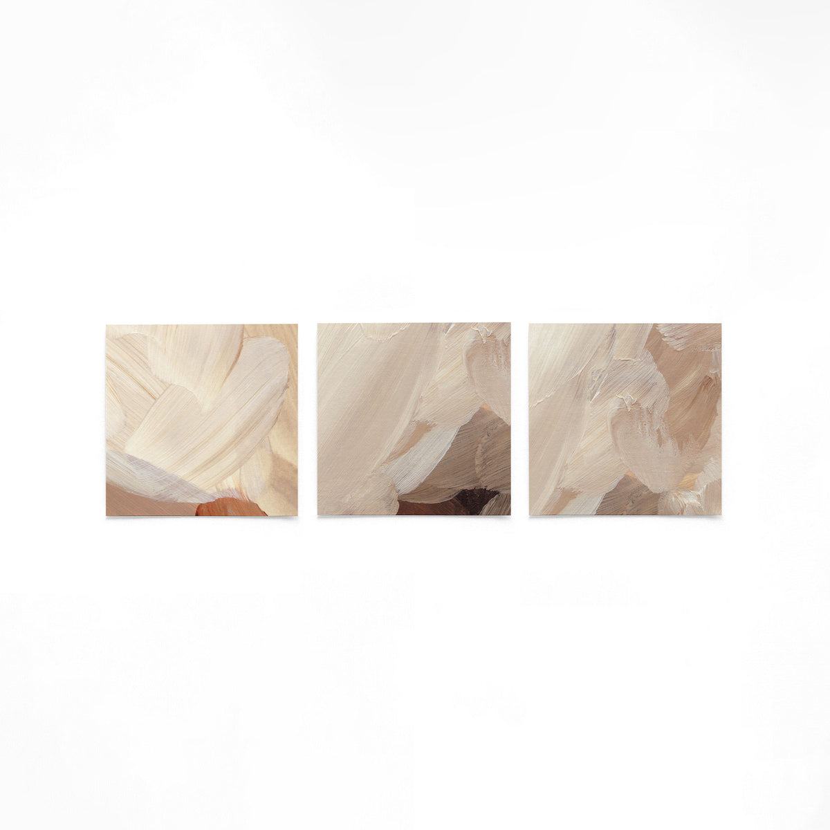 Drie vierkante posters met abstracte beige schilderijen op een gebroken witte achtergrond