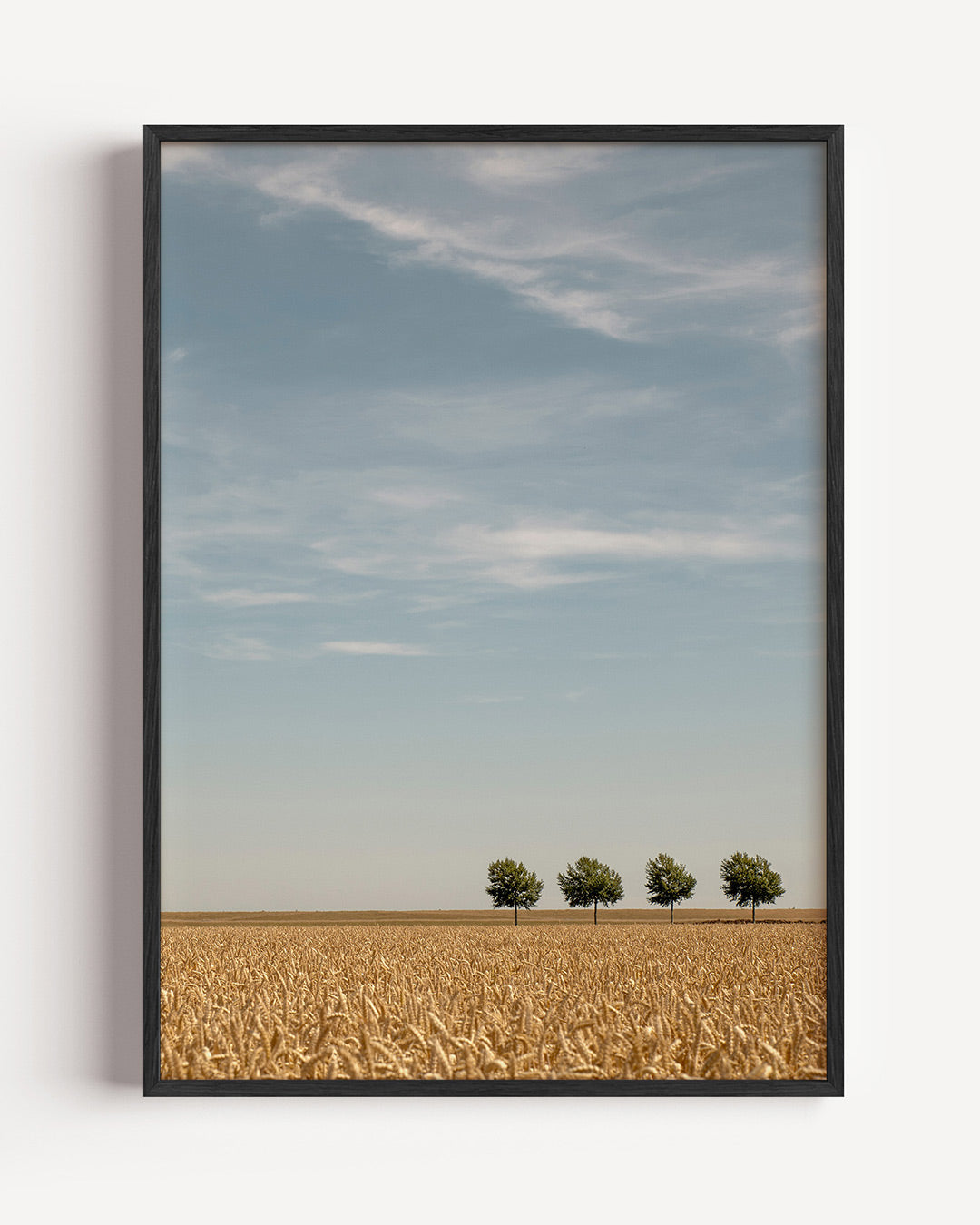 Rustig landschap poster – portret wanddecoratie – een uitgestrekt veld met gouden graan en vier bomen aan de horizon onder