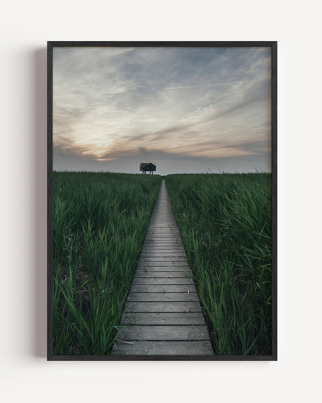 Rustige landschapspad poster – portret wanddecoratie – een lang houten pad leidt door groene velden naar een silhouet van een