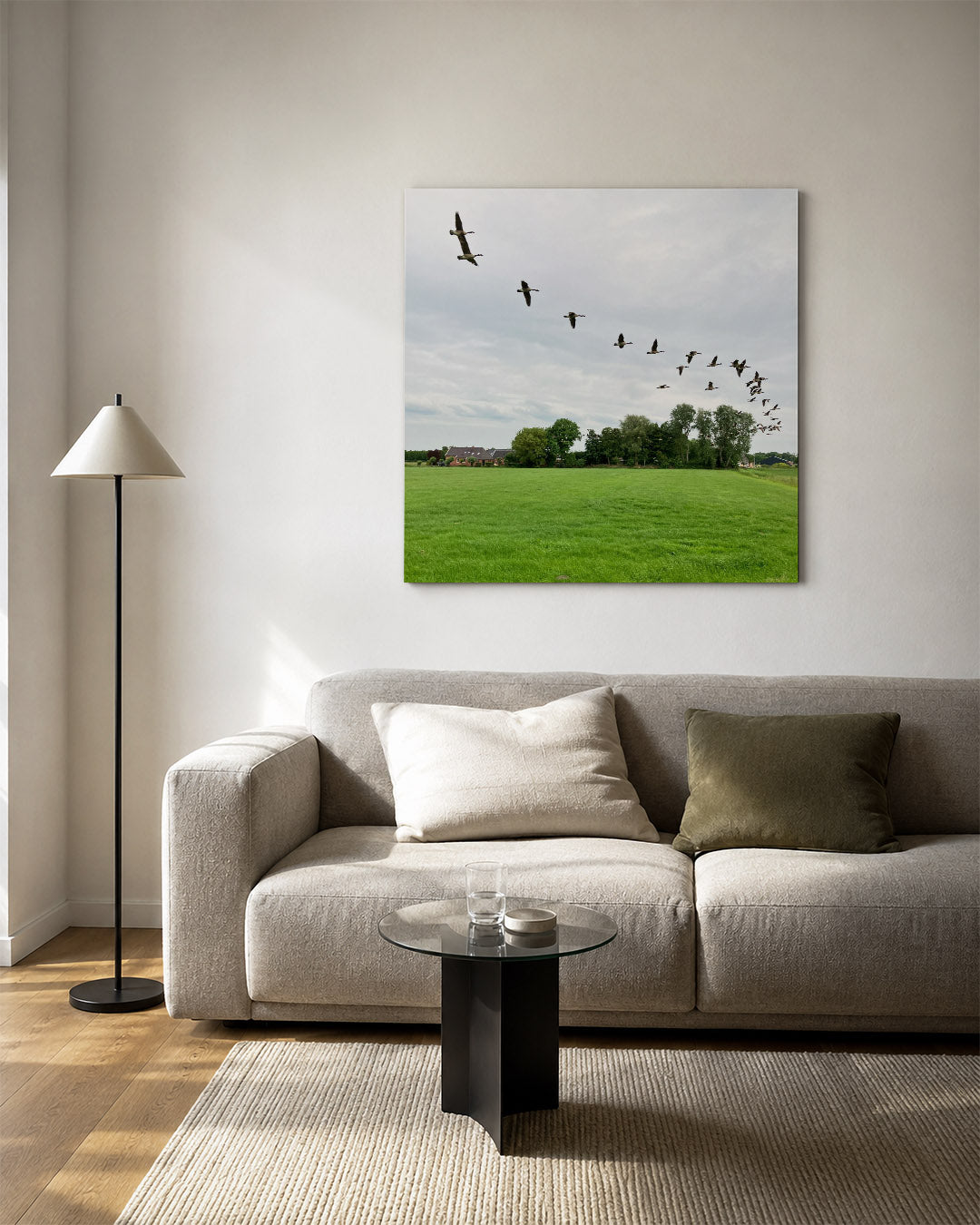 Vliegende vogels kunstwerk – vierkante wanddecoratie – een groep vogels vliegt in formatie over een groen veld met bomen en