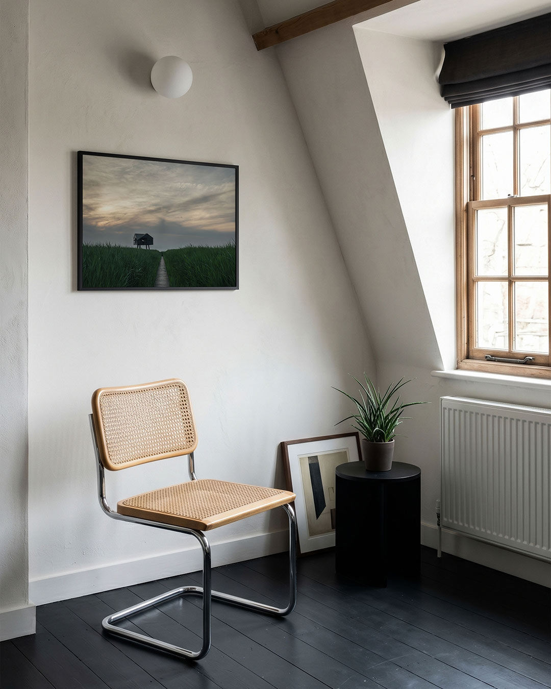 Hut in het veld poster – tweede productweergave – een houten hut staat in een uitgestrekt groen veld onder een bewolkte