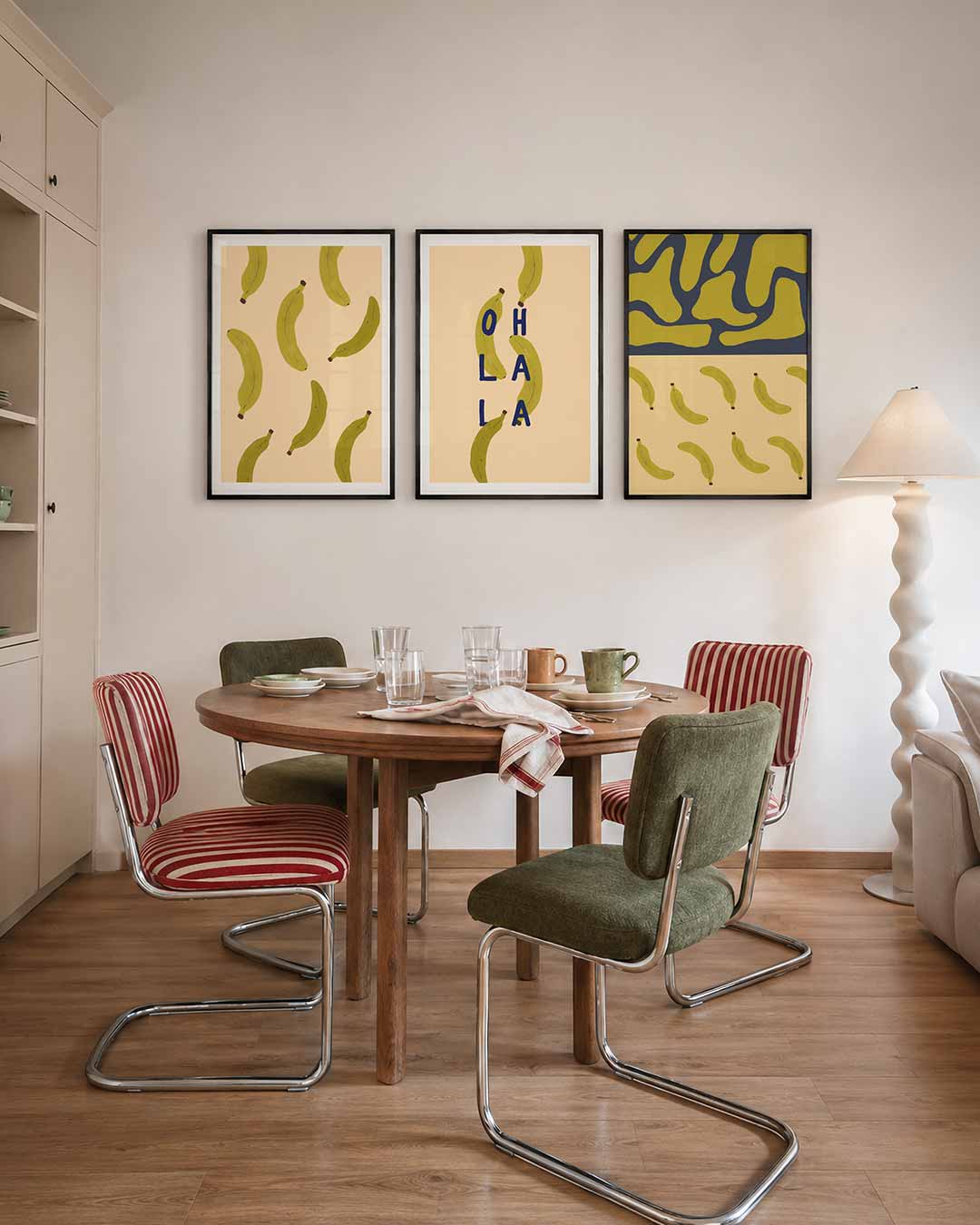 Speelse bananen driedelige posterset – groene bananen verspreid over een zachte perzikkleurige