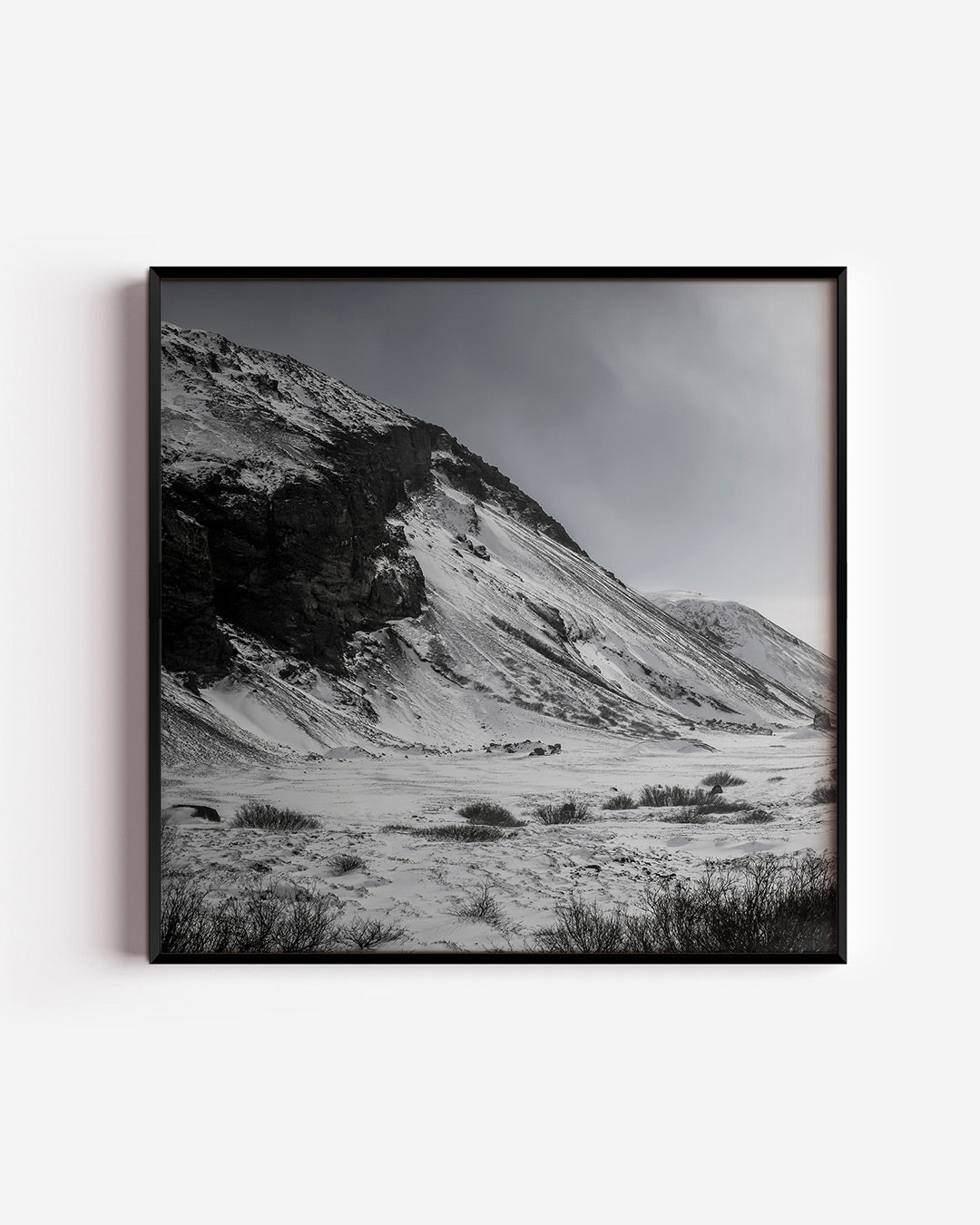 Besneeuwde bergen poster – vierkante wanddecoratie – een serene winterlandschap met besneeuwde bergen en een bewolkte lucht.