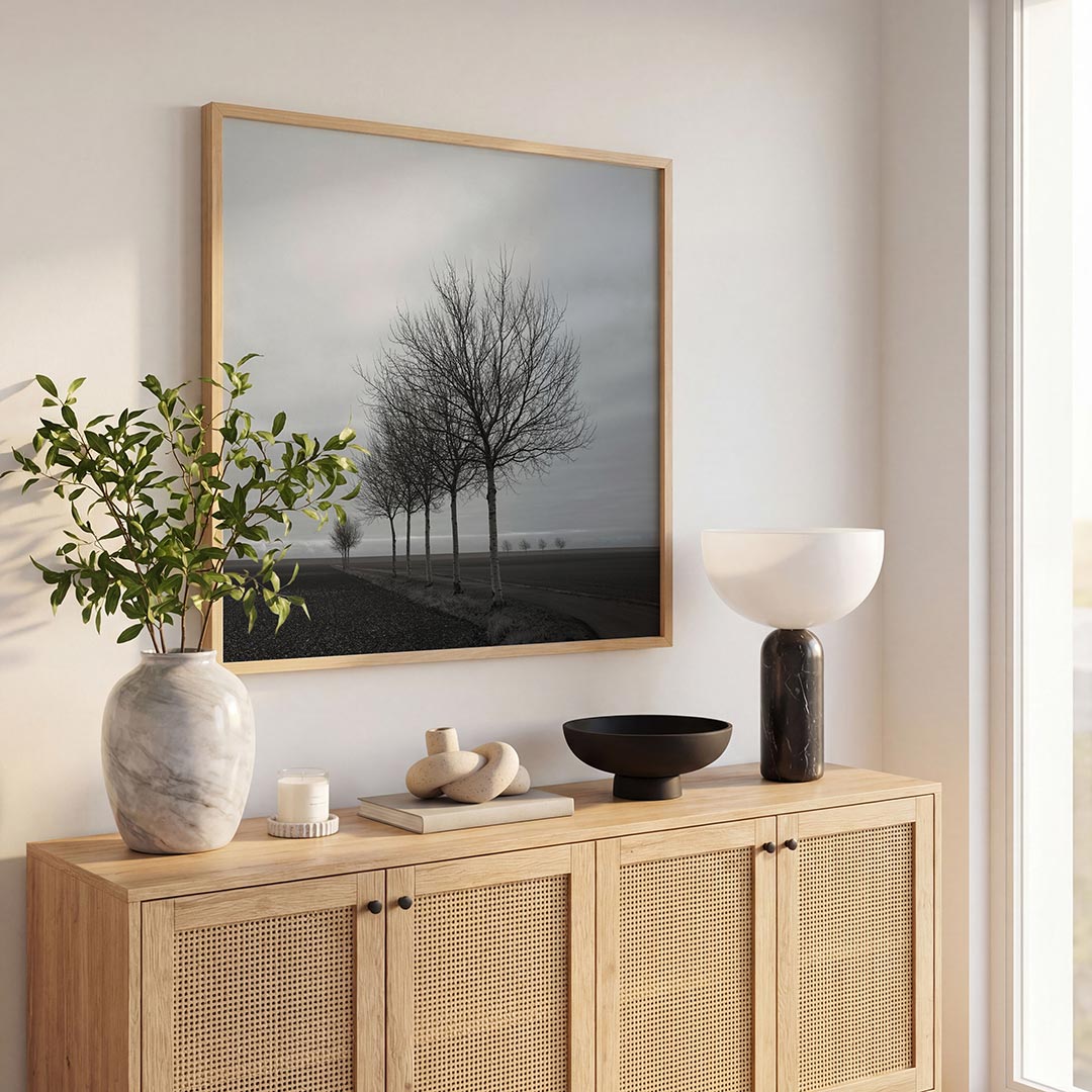 Landschap met bomen poster – tweede productweergave – een rij kale bomen langs een pad in een open landschap. De lucht is