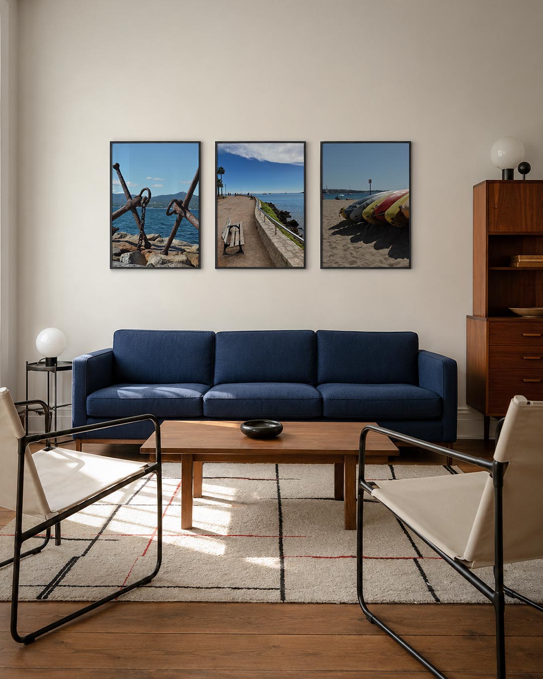 Anker en zee driedelige posterset – twee verweerde ankers rusten op rotsen aan de kust. De blauwe zee en lucht vormen een