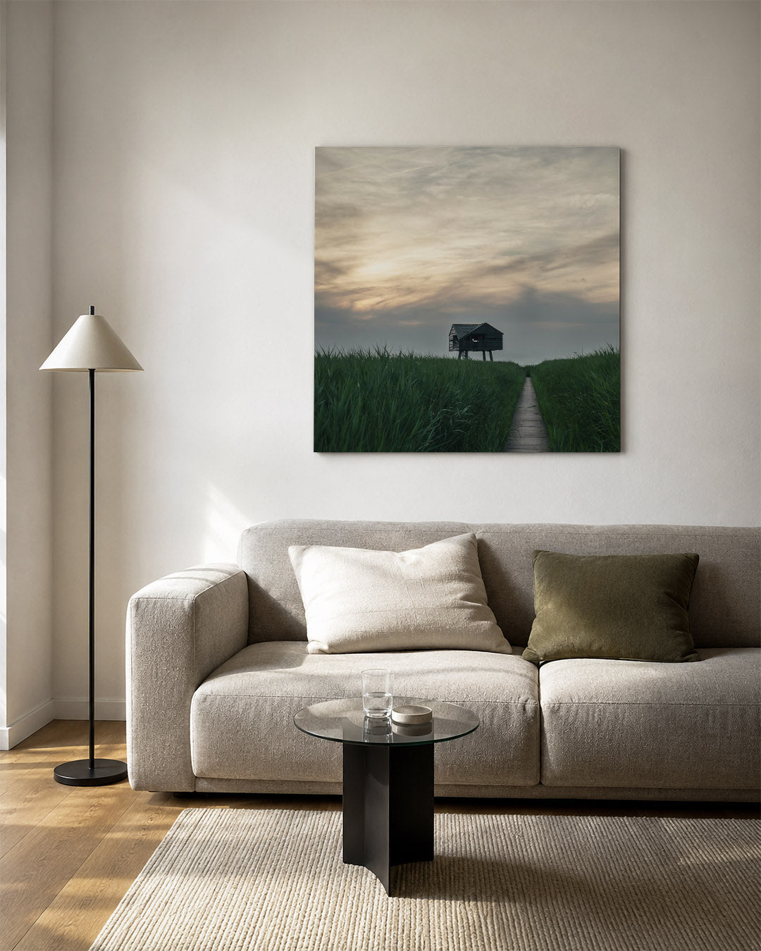 Houten hut kunstwerk – vierkante wanddecoratie – een houten hut staat op palen te midden van hoge groene grassen onder een