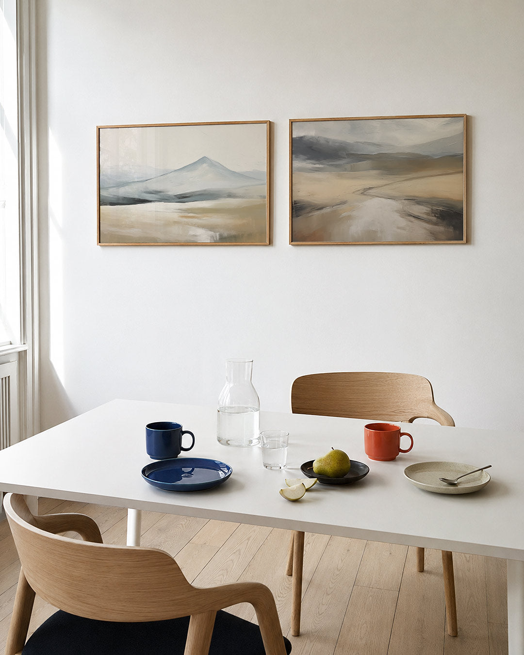 Twee liggende posters met bergachtige vormen in blauw en beige, aan de muur in een interieur