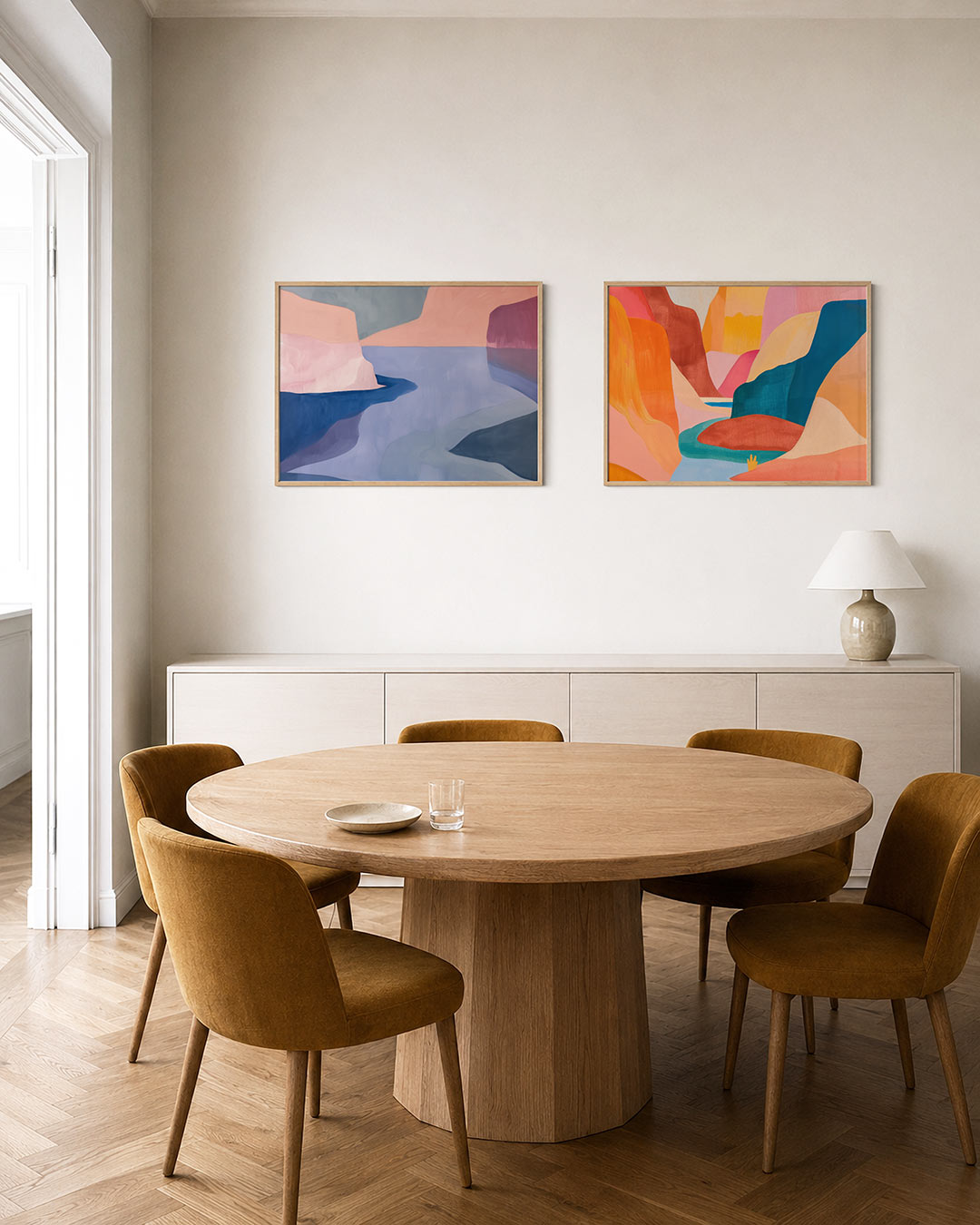 Twee liggende posters met vloeiende vormen en zachte kleurvlakken in roze, blauw en grijs, aan de muur in een interieur