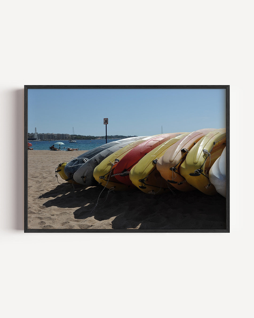 Kleurrijke kajaks op strand poster – liggende wanddecoratie – deze poster toont een rij kleurrijke kajaks op een zandstrand