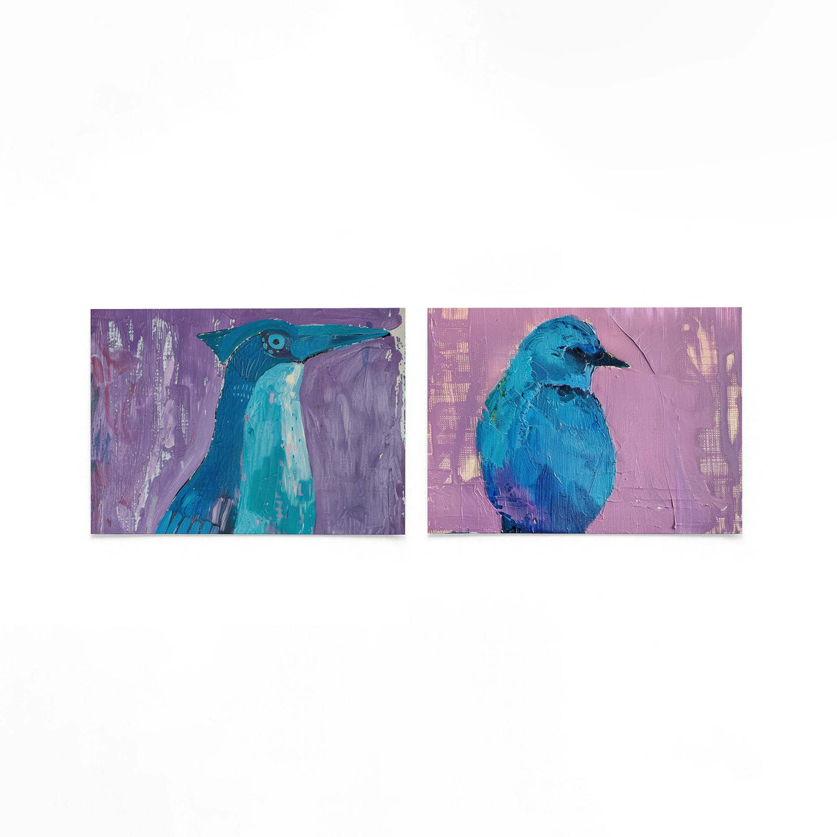 Twee liggende posters met een speelse vogelvorm in blauw en turquoise op een gebroken witte achtergrond