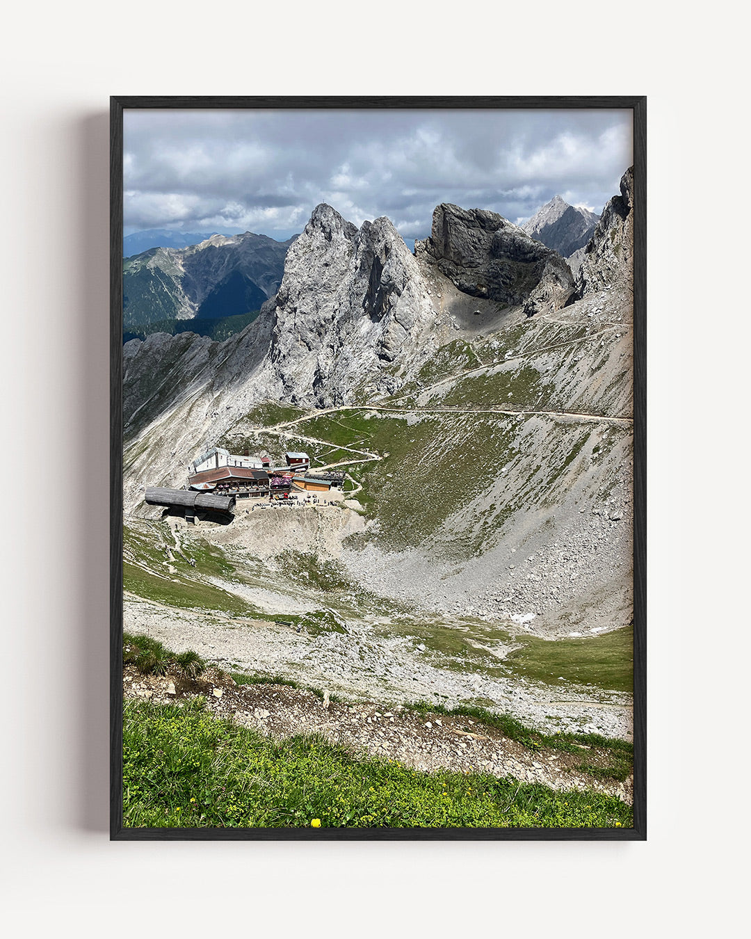 Berglandschap met chalet poster – portret wanddecoratie – een berglandschap met rotsformaties en een klein chalet. De groene