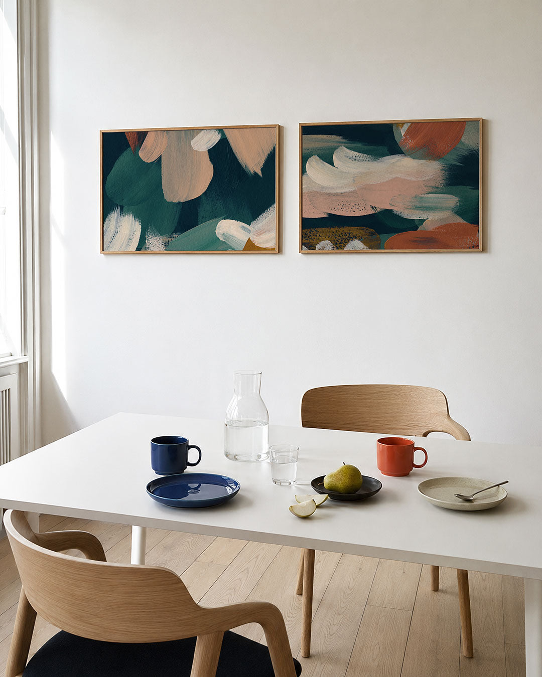 Tweedelige posterset met zachte penseelstreken in groen, beige en wit, getoond in een interieur