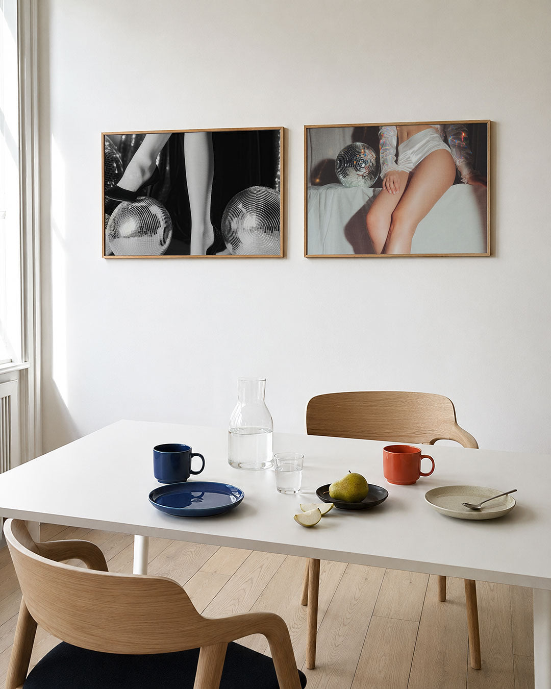 Tweedelige posterset met benen in hoge hakken rustend op glanzende spiegelbollen, getoond in een interieur
