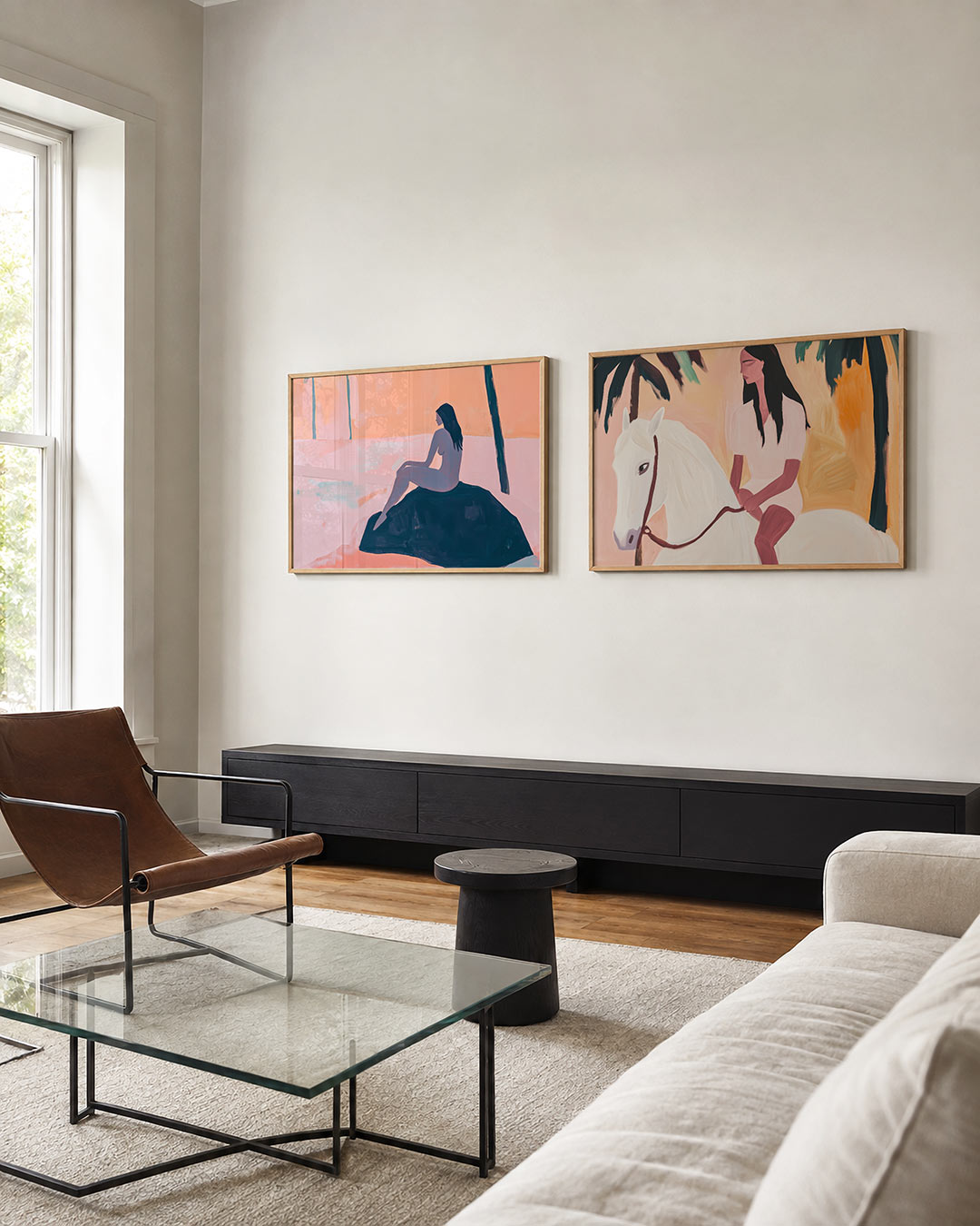 Twee liggende posters met een vrouwelijk silhouet tegen een perzik- en roze achtergrond, aan de muur in een interieur