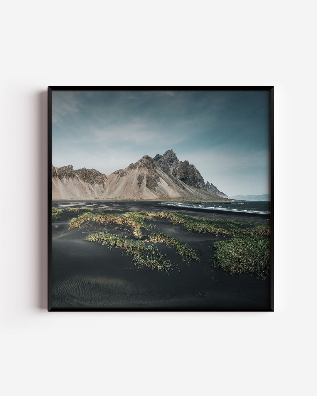 Berglandschap poster – vierkante wanddecoratie – een indrukwekkend berglandschap met zwarte zandstranden en groene vegetatie.