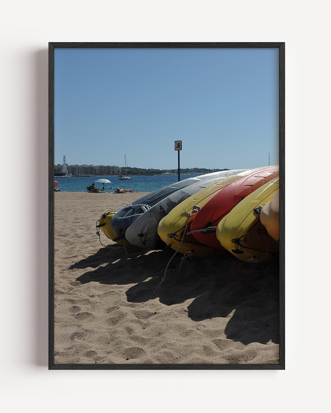 Kleurrijke kajaks op strand poster – portret wanddecoratie – deze poster toont een rij kleurrijke kajaks op een zonnig strand